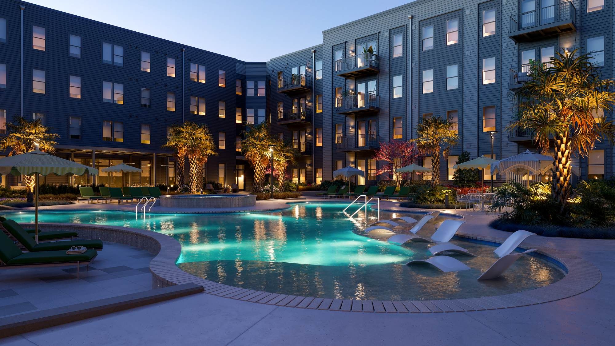 Evening view of the courtyard pool at VERVE Columbia, with glowing water, in-pool loungers, and ambient lighting surrounded by modern apartment buildings and palm trees.