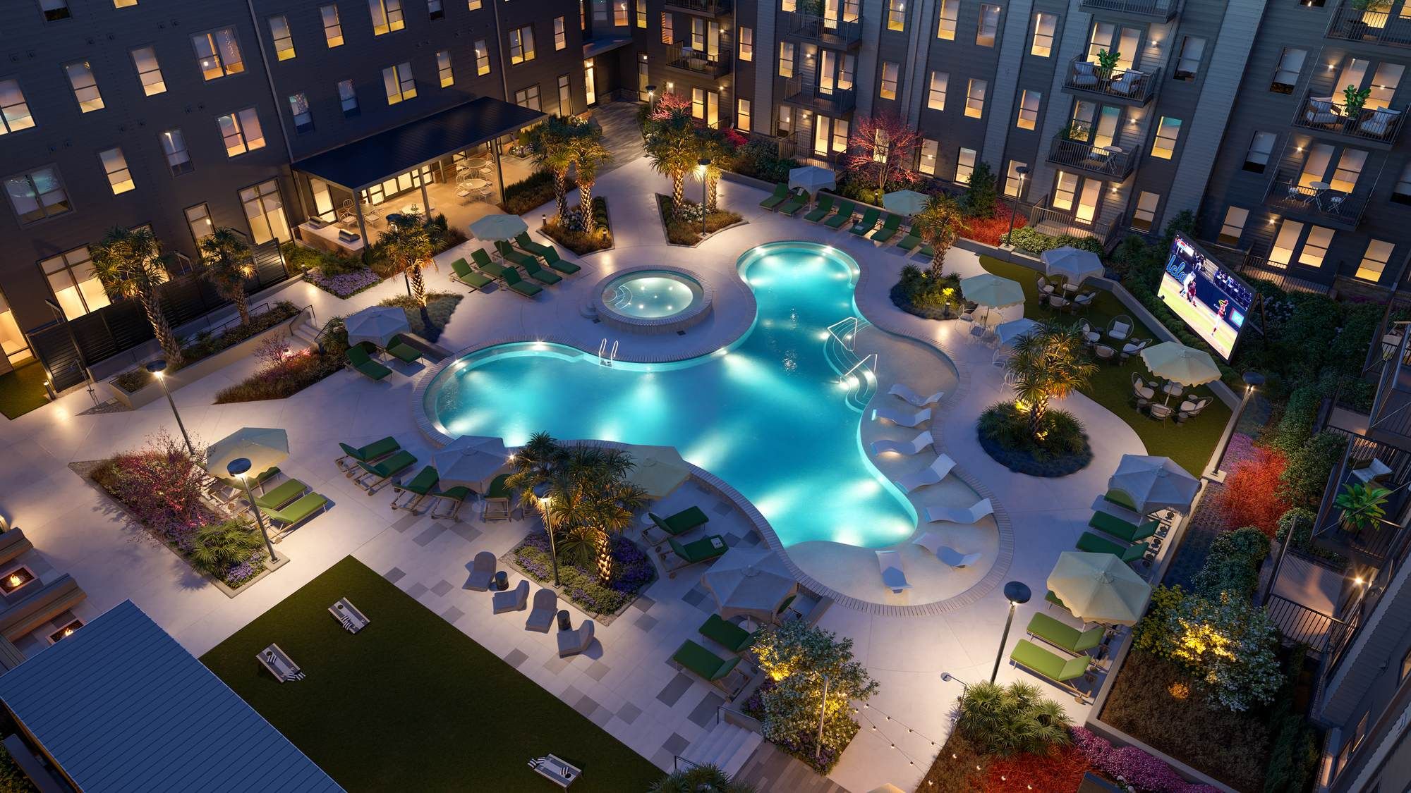 Aerial view of the illuminated pool courtyard at VERVE Columbia at night, featuring glowing water, palm trees, and ample lounge seating in a vibrant, resort-style setting.