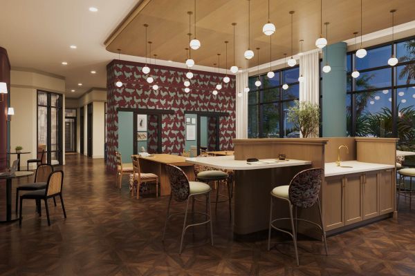 Study lounge at VERVE Columbia featuring a long communal worktable, patterned accent wall, modern globe pendant lighting, and stylish barstool seating—designed for focus and collaboration.